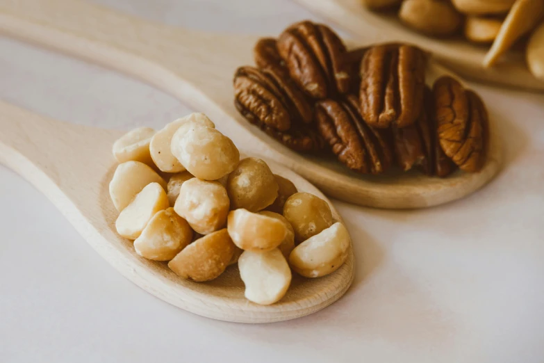 a table holding wooden spoons filled with nuts and pecans