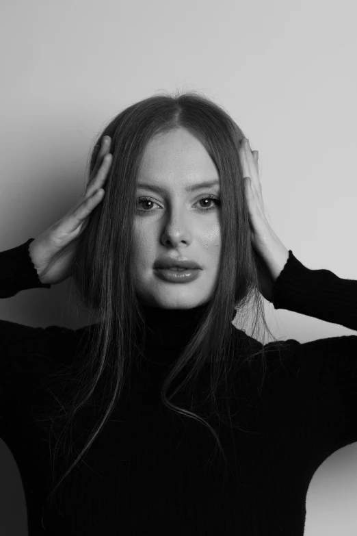 black and white image of woman with hands on hair