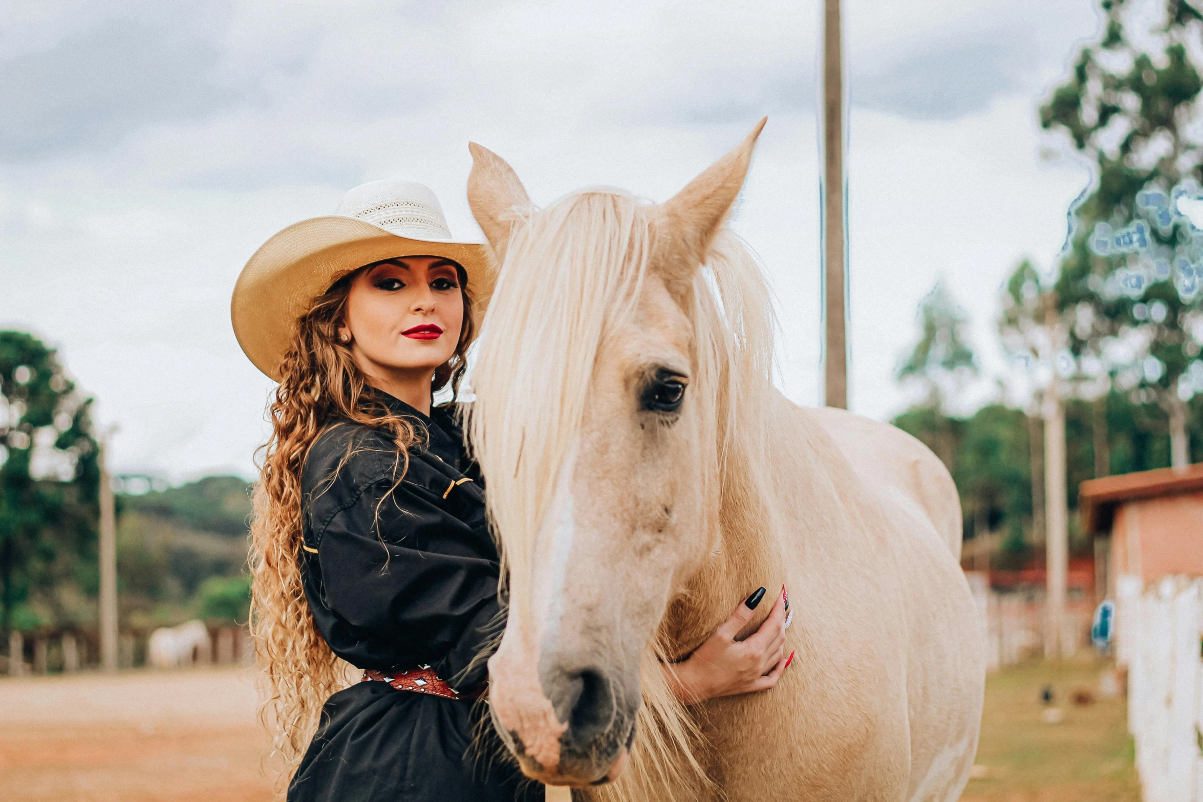 a woman is posing with a horse outside