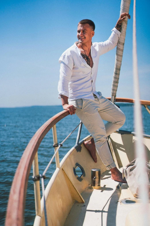 a man sitting on top of a boat next to the ocean