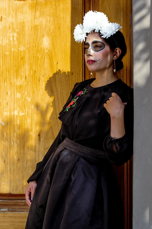 woman dressed up in black dress, and flowers on head