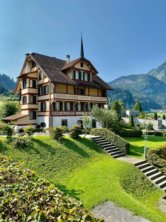 a building is in the middle of a grassy area with many flowers on it