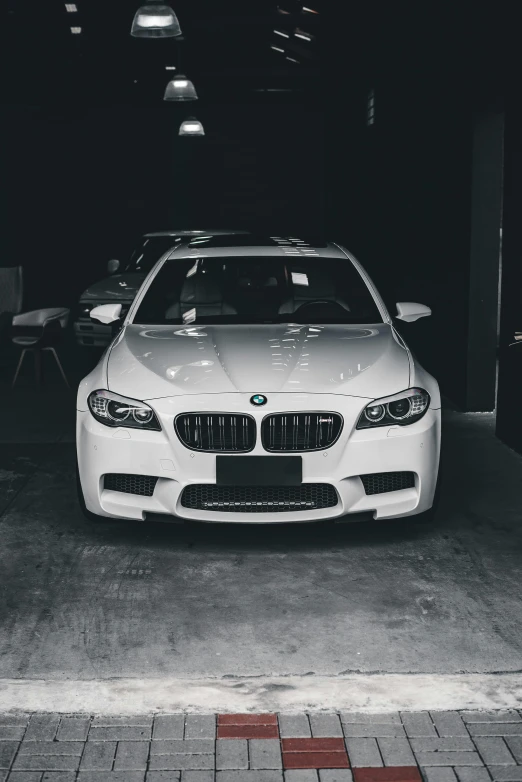 a white car parked in a garage, with a car dealership across the street