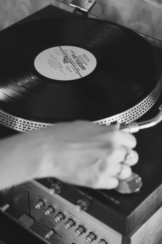 a person pressing a record with an antique turntable