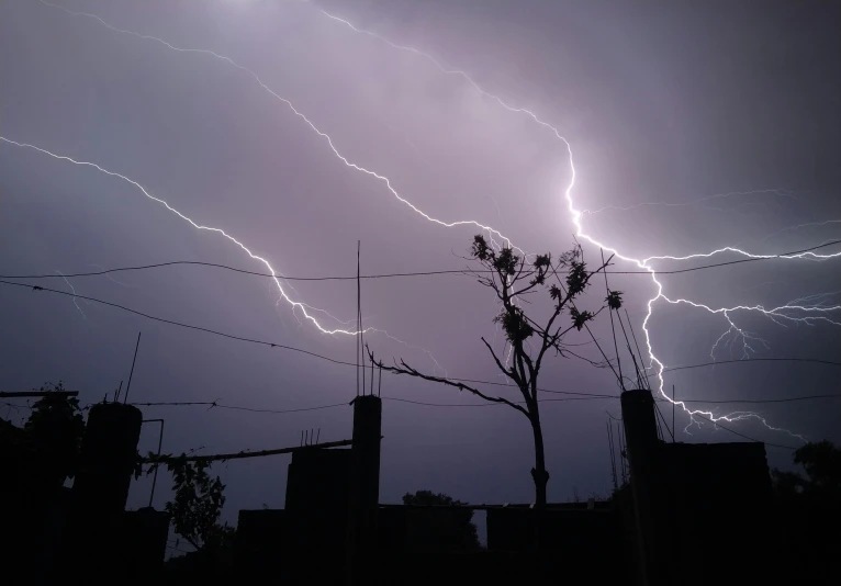 a dark storm with lightning coming in over city streets