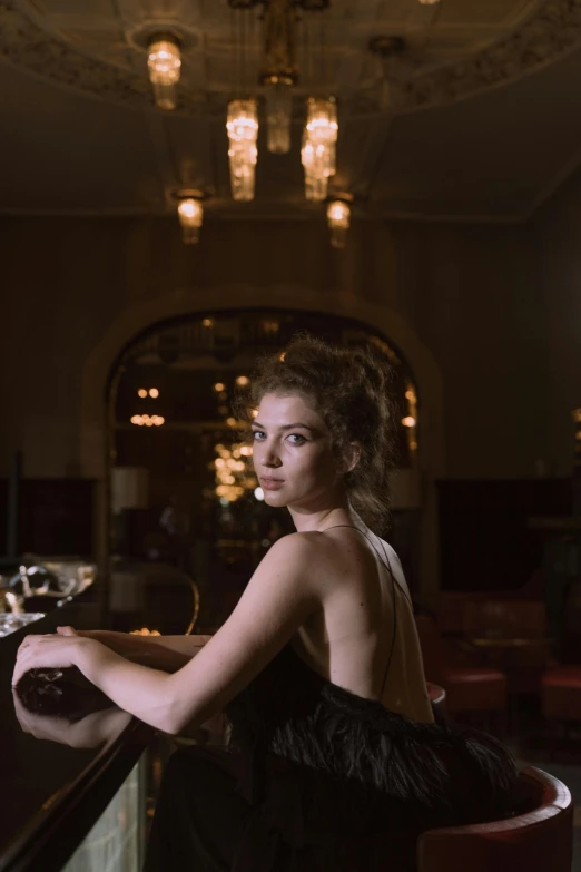 woman in an elegant dress poses in a restaurant