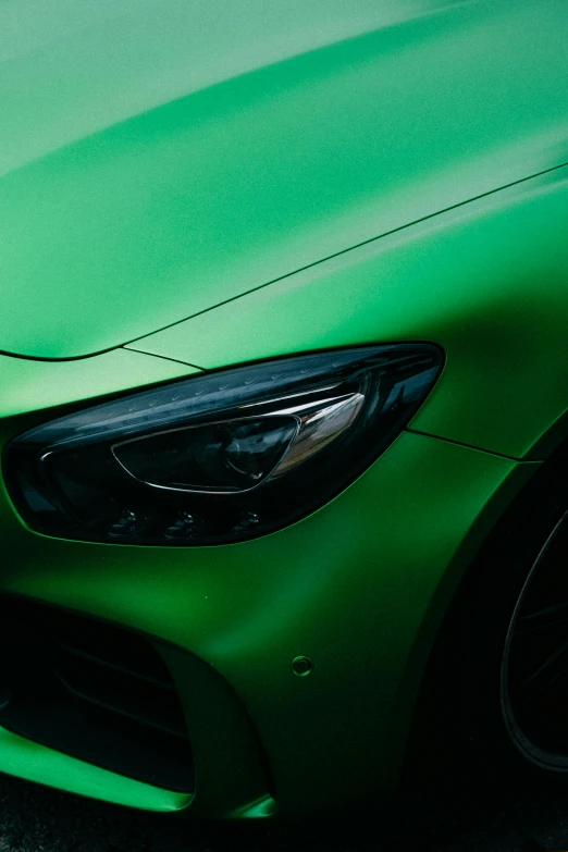 a green colored mercedes c - class on a black street