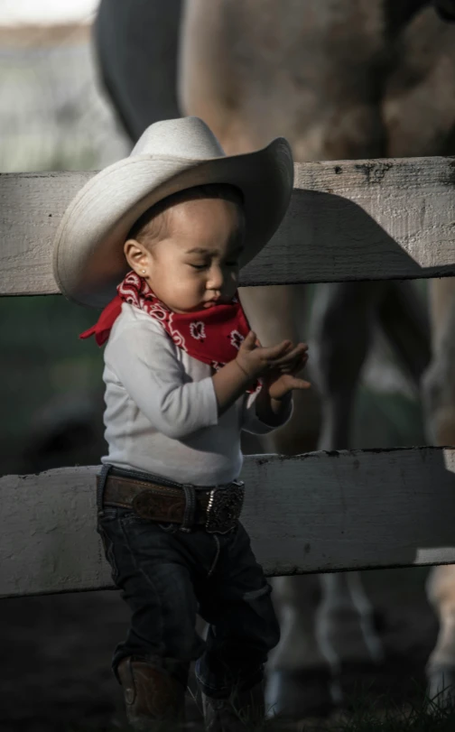 a small child wearing a cowboy hat and scarf