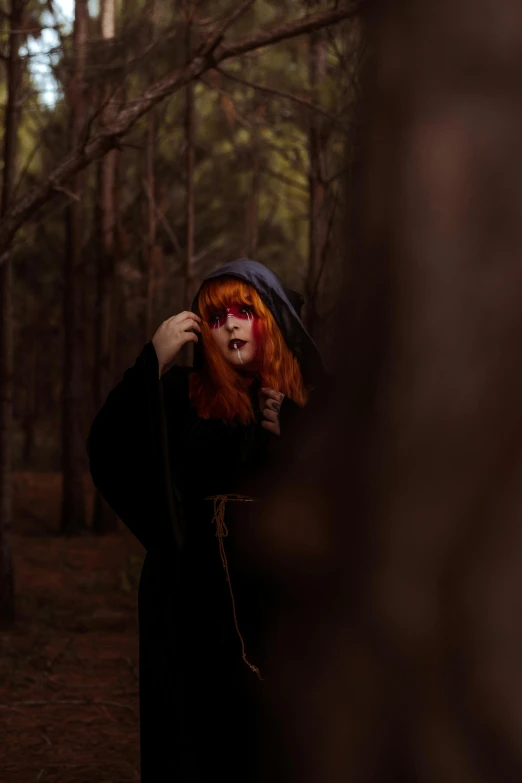 a woman with red hair is wearing a long dark coat