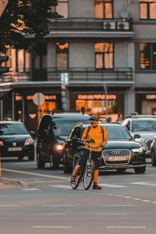 a person wearing a yellow shirt rides their bicycle through traffic