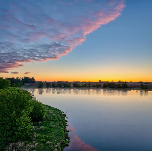 a sunset over the water and clouds in the sky