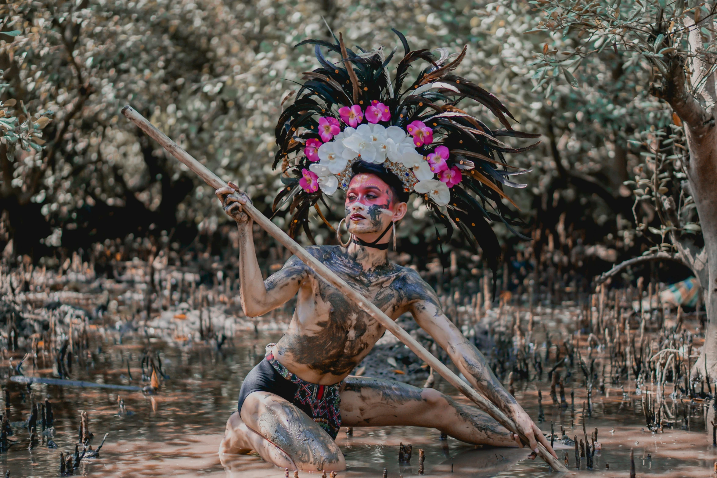 a man holding a stick with a bunch of flowers on it