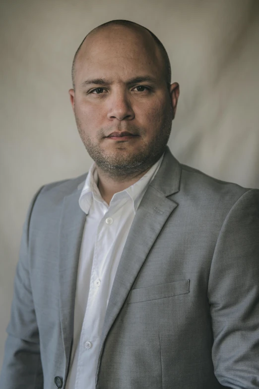 a man in a gray suit is posing for a picture