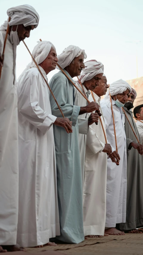 several old people in white, blue and beige outfits