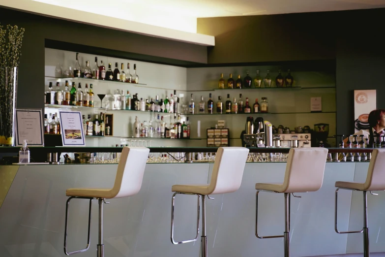 a bar with four stools lined up against the wall