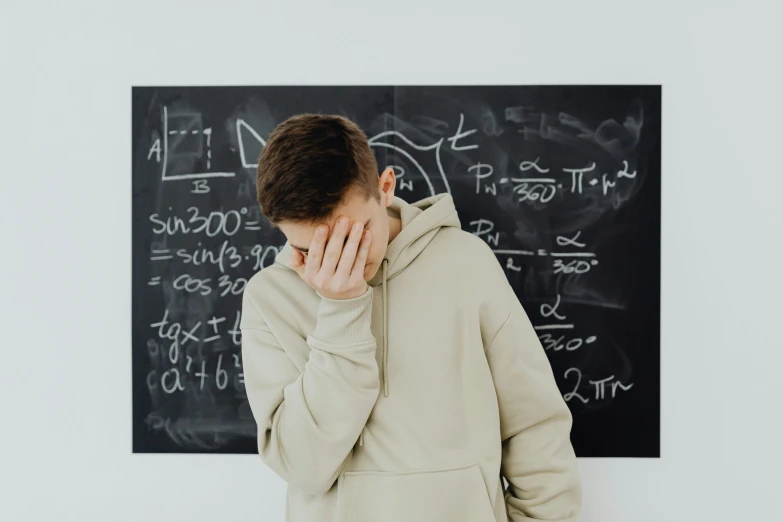 a young man looks up as he covers his face