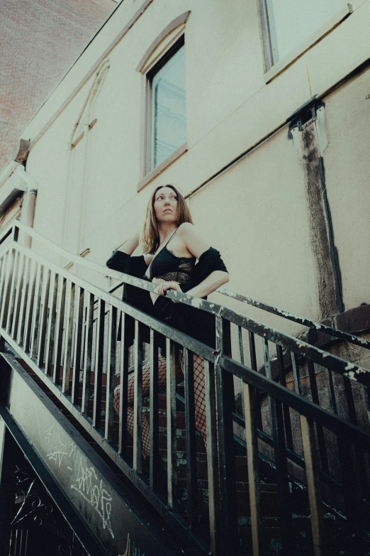 a beautiful woman sitting on a balcony railing