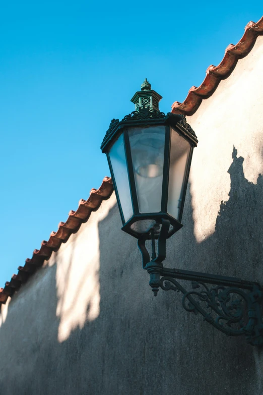 an old fashioned lamp is lit against the stucco