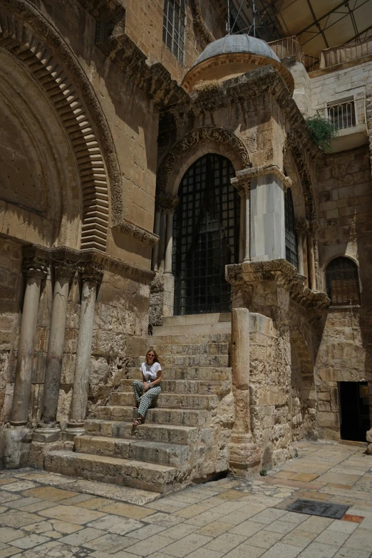 a man sitting on the steps next to some old buildings