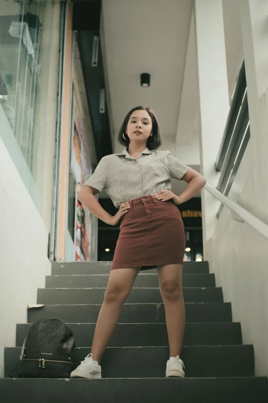 an attractive woman standing on some steps in front of a bag