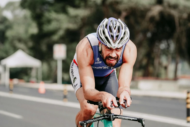 a man in bib shorts on a bike with a helmet