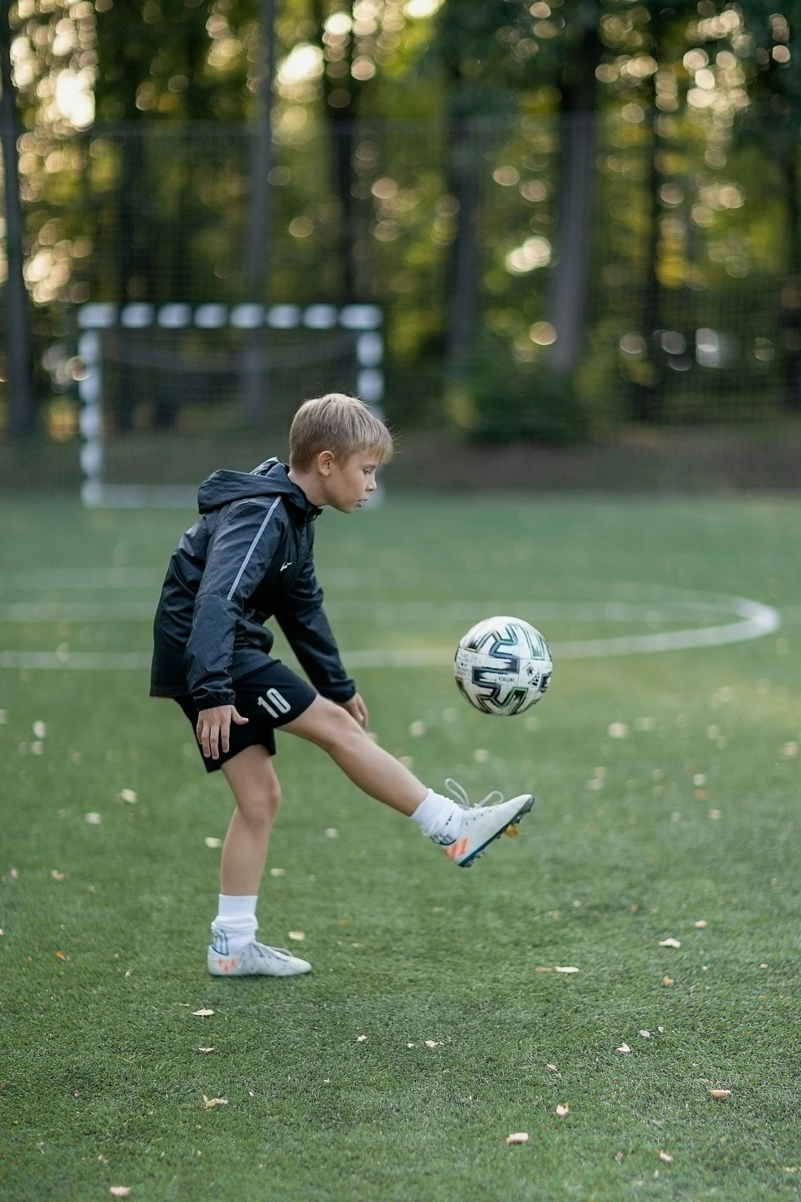 a boy in a soccer field prepares to kick the ball