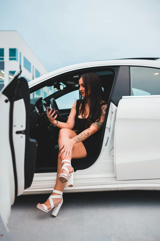 a young lady getting out of a white car