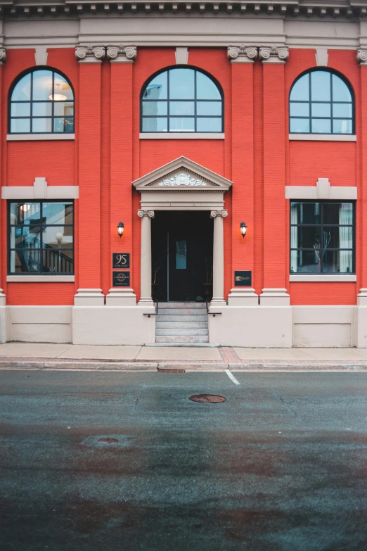 a red building with lots of windows and a dark road below