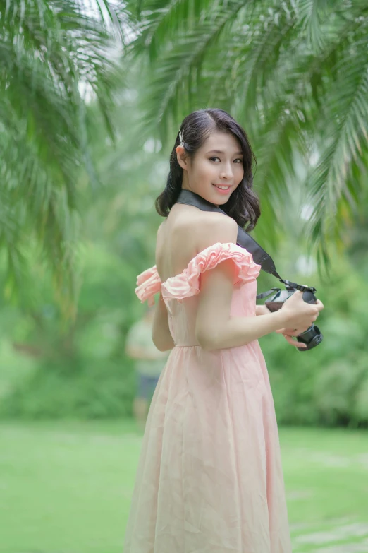 a woman holding a camera in the grass