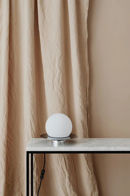 a white table lamp on top of a white counter