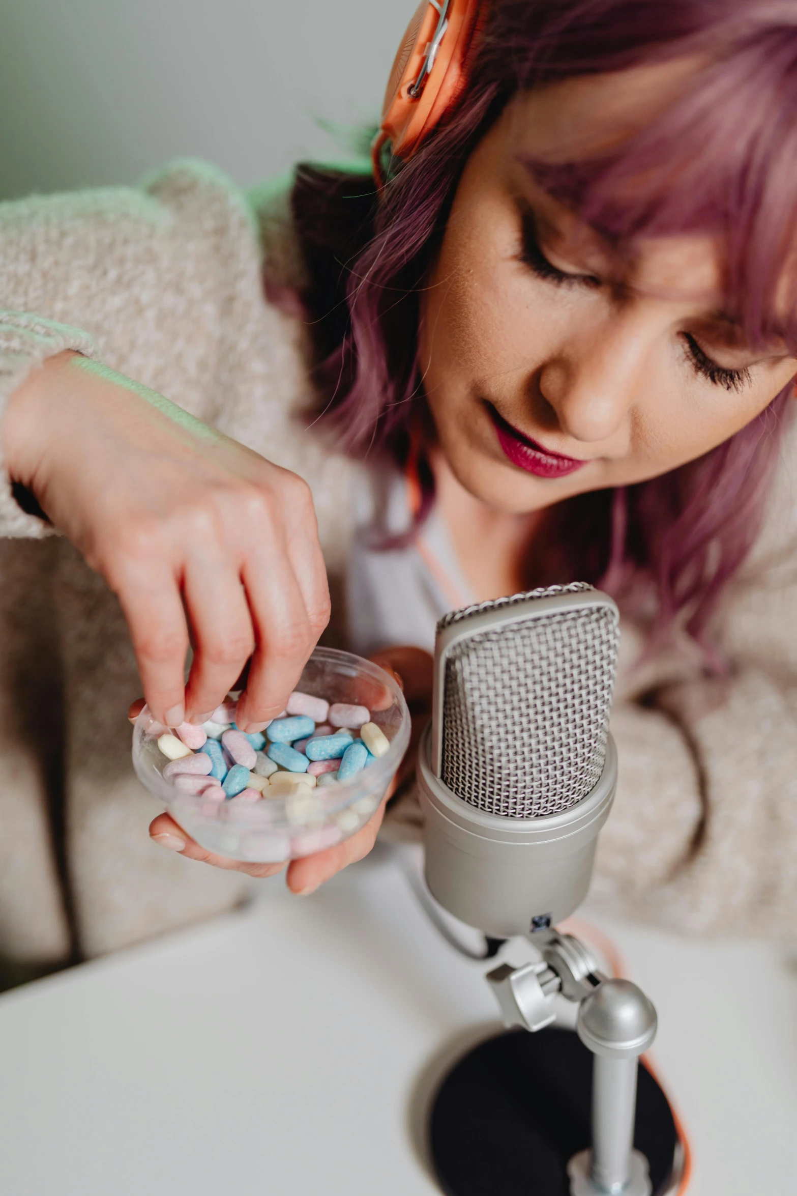 a girl with pink hair is playing around the medicine and looking at it