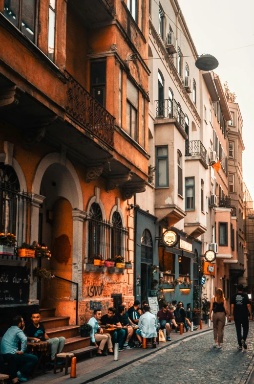 people sitting outside on benches near the sidewalk