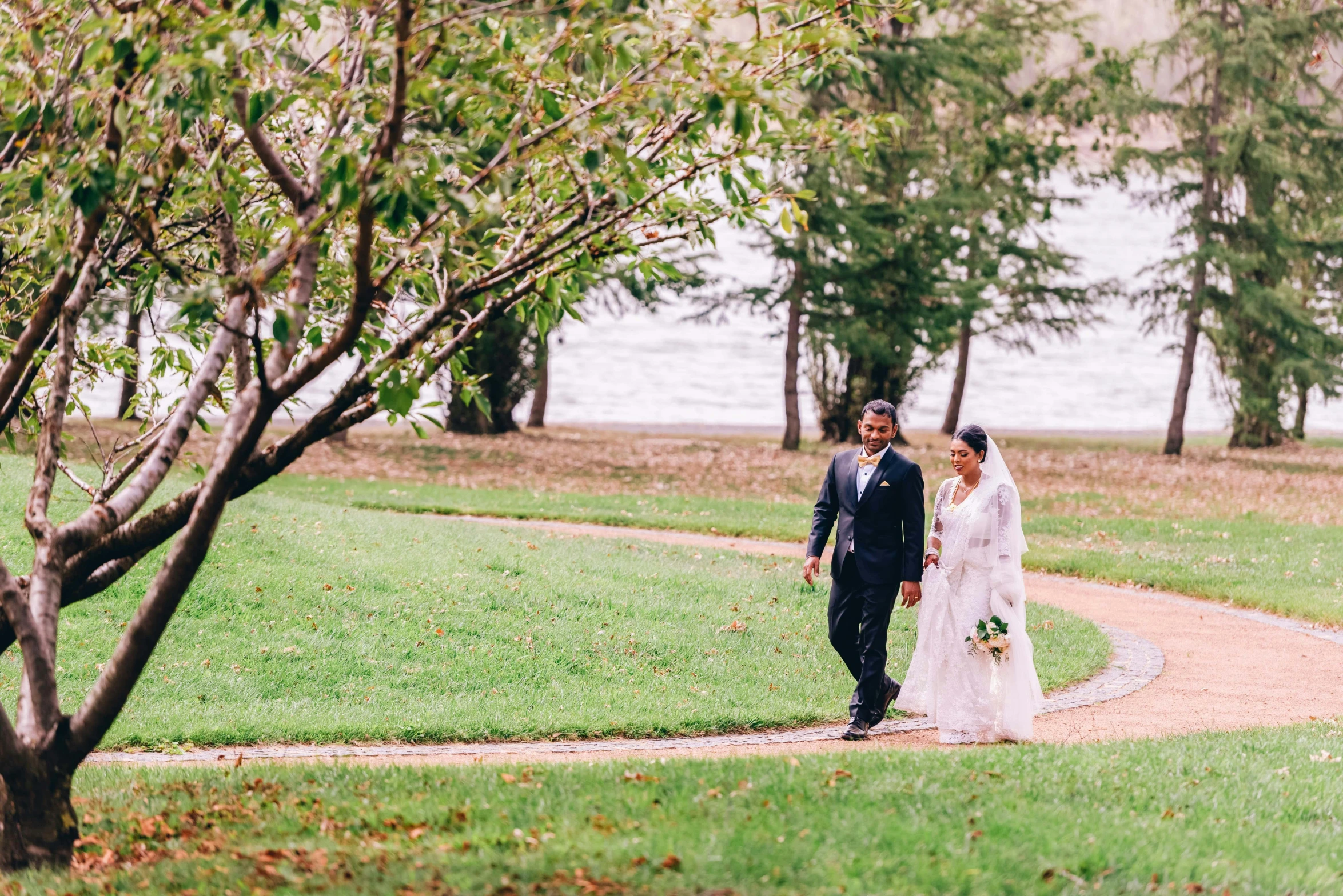 bride and groom walking through a leaf - strewn path