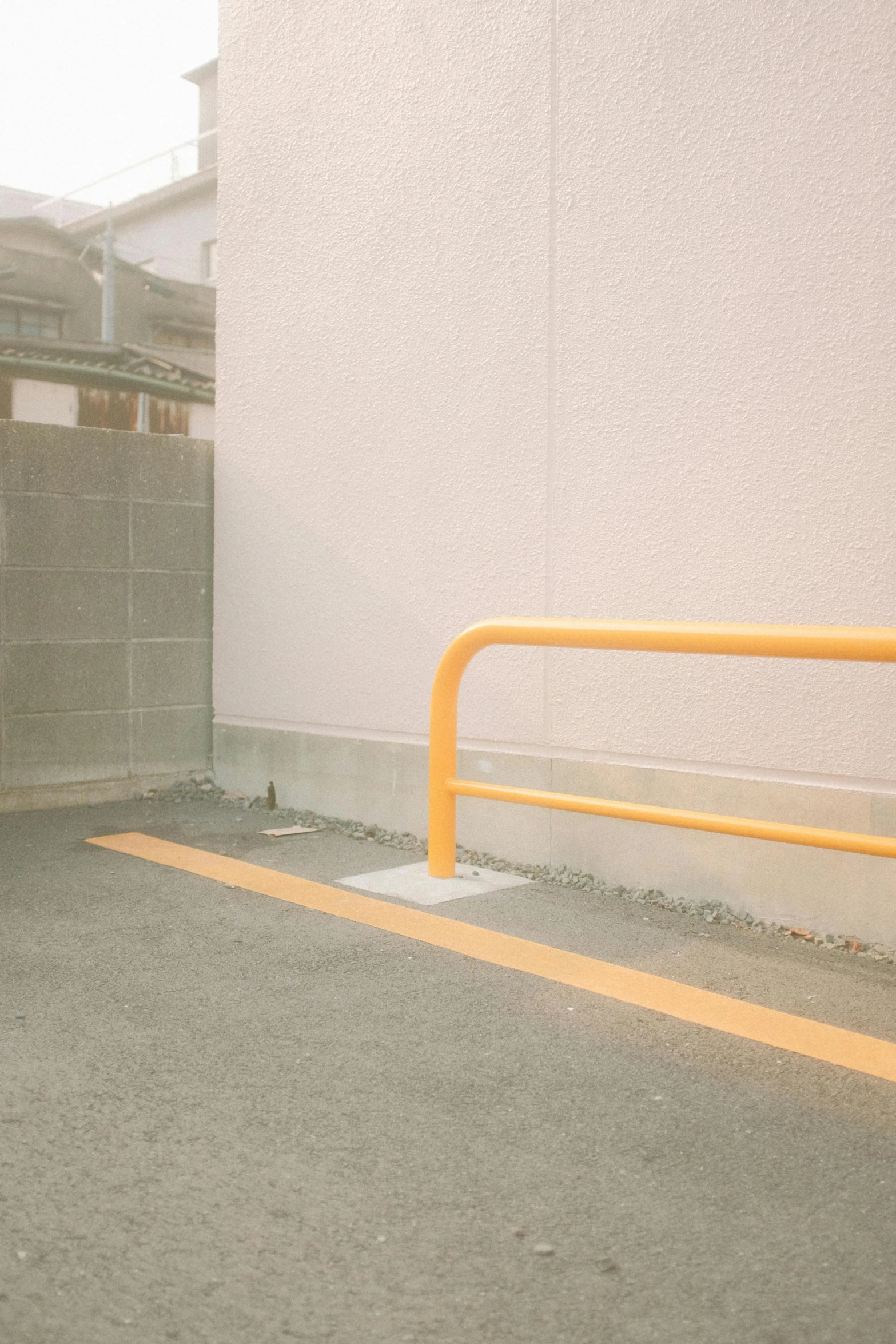 a yellow gate in front of a gray building