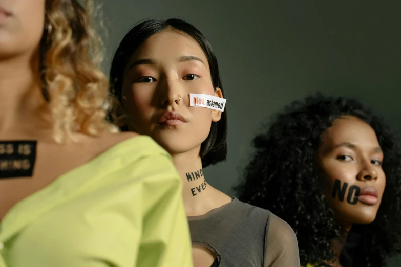 three women wearing fake tape on their faces