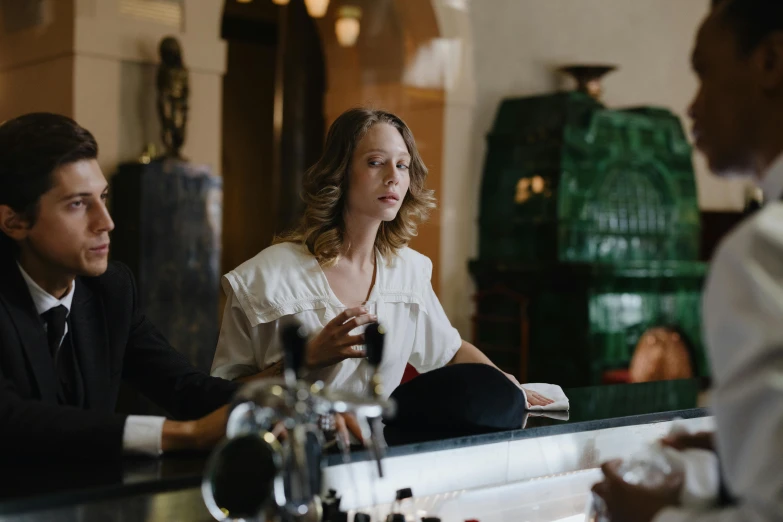 people sitting at a bar with a man on the counter