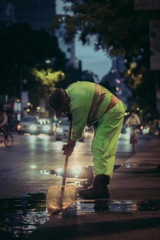 the man with yellow pants is shoveling through some water