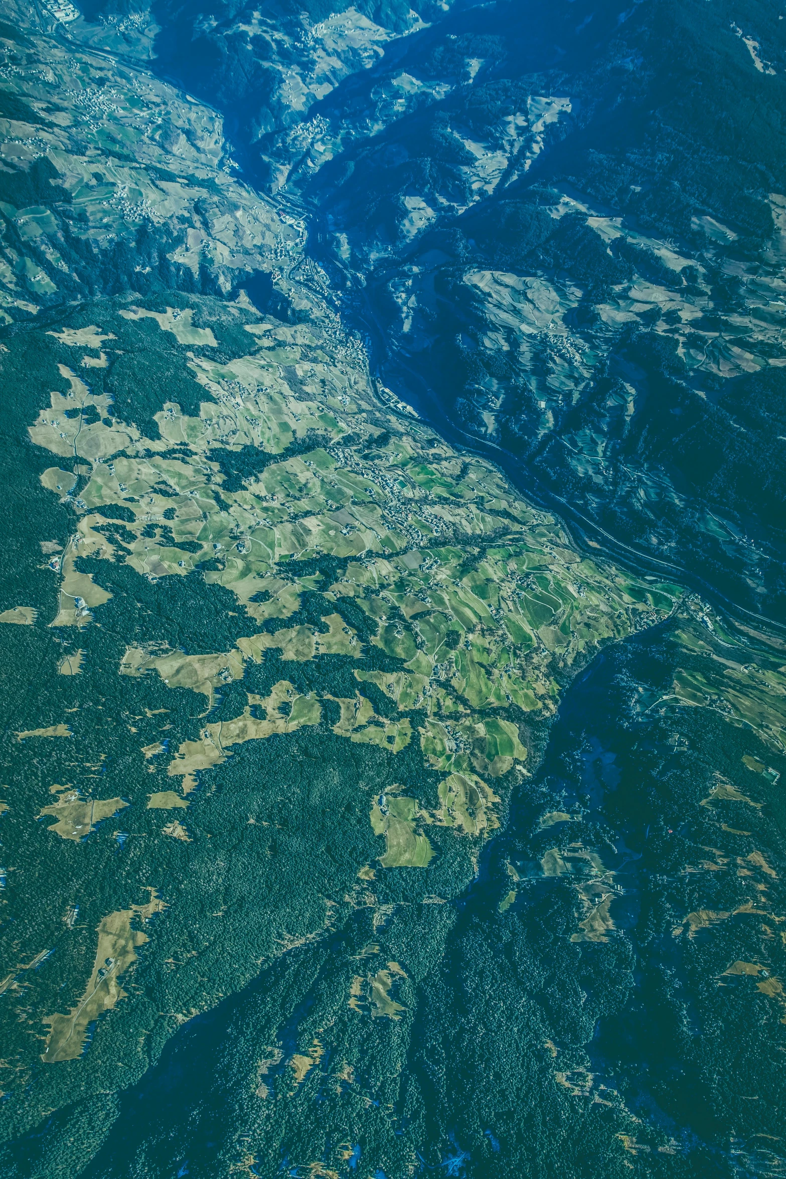 an aerial view of mountains and rivers taken from a plane