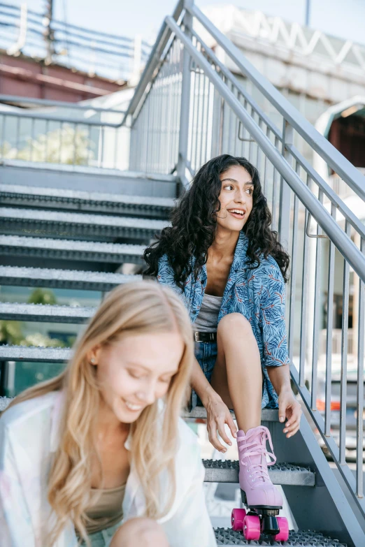 a girl is laughing as she leans against a skateboard on the steps