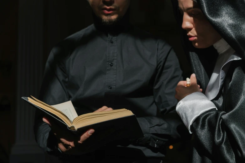 a man and woman are looking at an open book