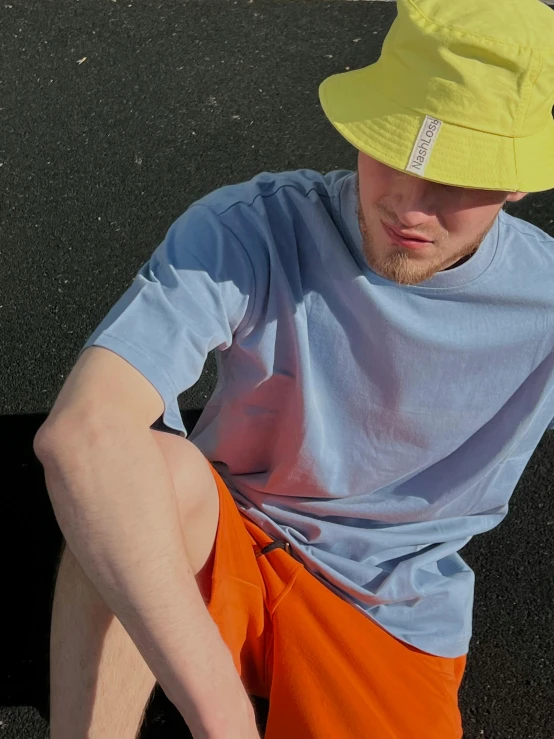 a man wearing orange shorts while sitting on the ground
