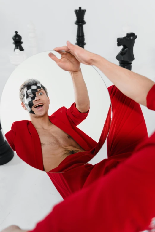 man with clown makeup on smiling in mirror