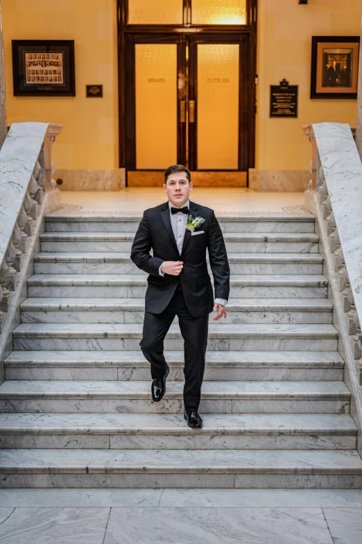 the young man is standing on the steps in front of a building