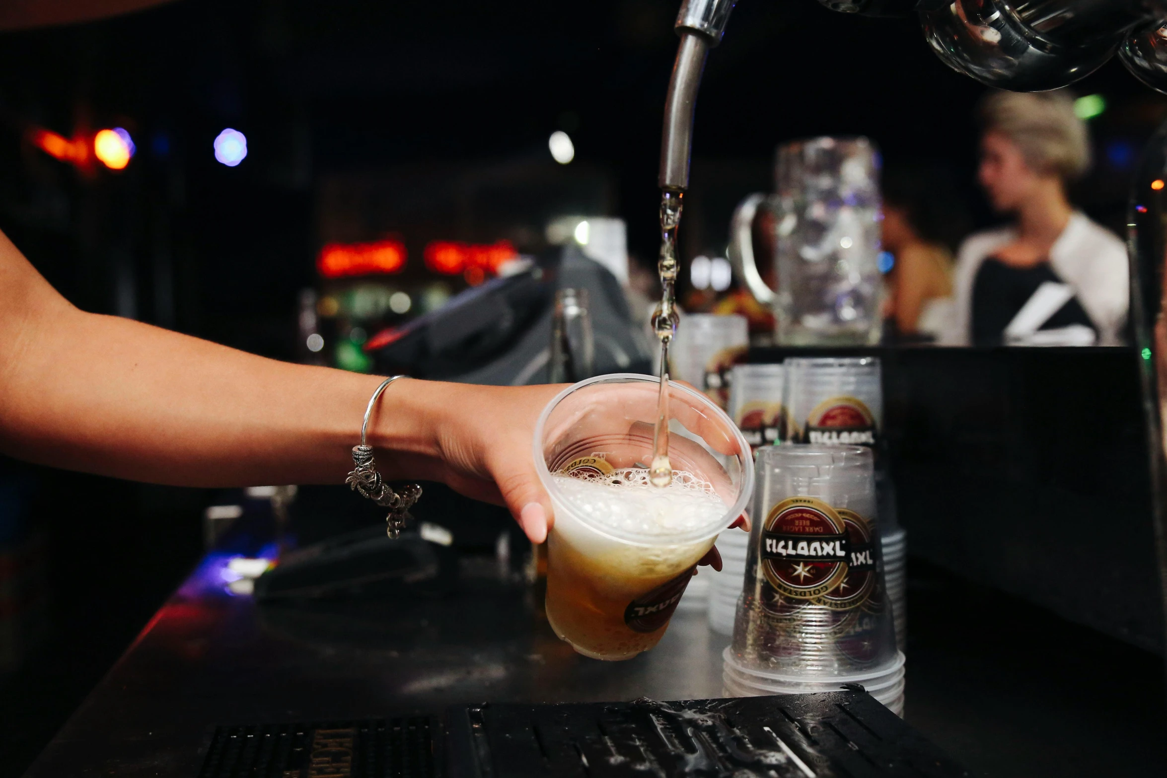 person pouring drinks at bar area on night