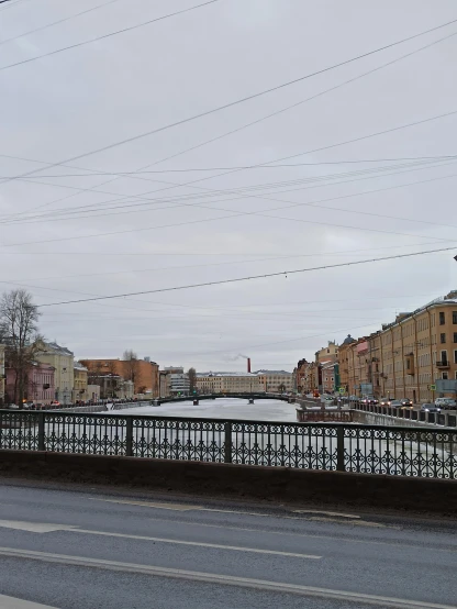 a frozen canal with power lines and a bridge in the background