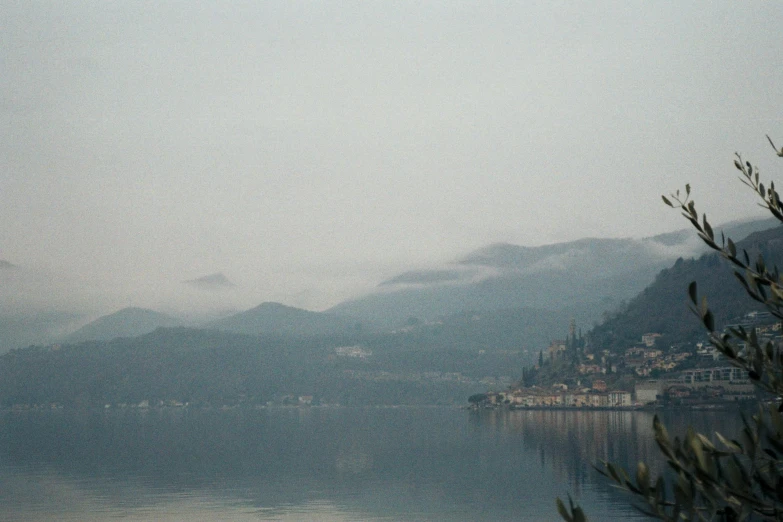 a misty po of a bay next to mountains