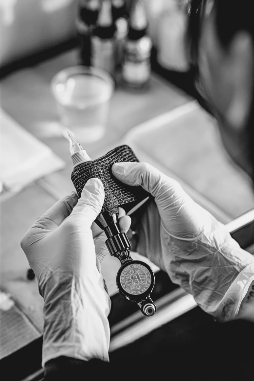 a person wearing white gloves holds up a cell phone