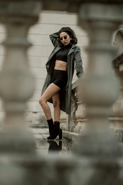 a woman in a long coat posing on steps