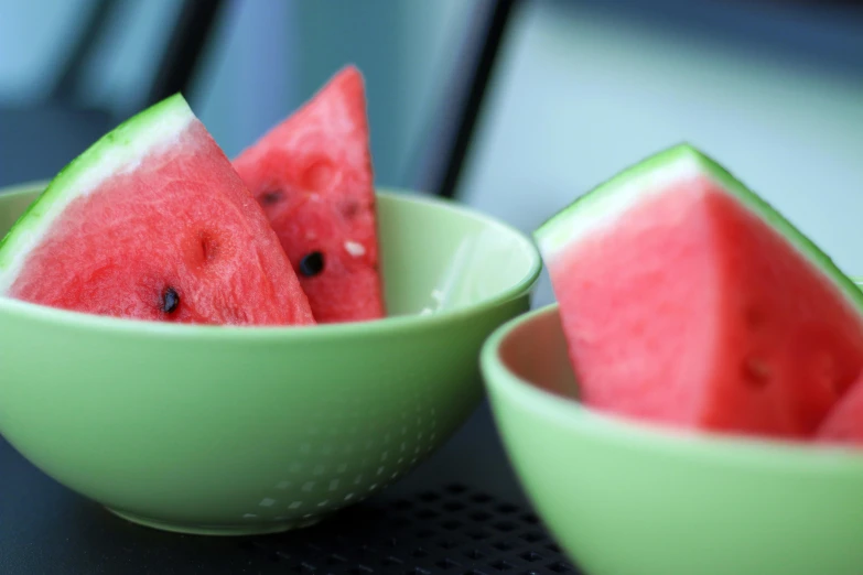 a couple of bowls with pieces of watermelon in them