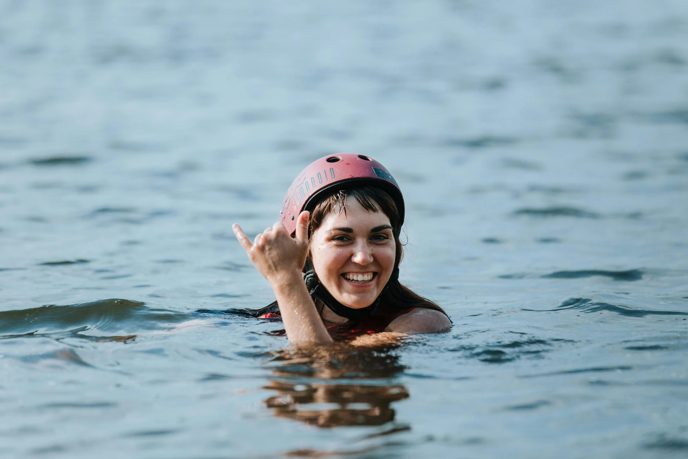 a woman wearing a helmet is floating in the water